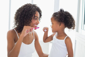 Mother and daughter brushing teeth